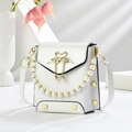 Detail view of white crocodile pattern crossbody bag with swan buckle and pearl handle - White