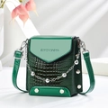 Detail of dark green crossbody bag featuring crocodile texture and glossy leather flap - Green