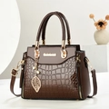 Dark brown crocodile embossed tote bag with gold leaf pendant on a minimalist background - L24 H19 W12 / Coffee
