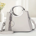 Détail d'un sac à main gris clair en cuir grainé avec poignée ronde en métal argenté - Gris