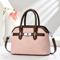 Detailed close-up of pink shell bag with silver rotary lock and lychee texture - Pink