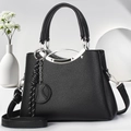 Schwarze Damen-Handtasche aus PU-Leder mit Silbergriffen und geflochtenem Anhänger - Schwarz