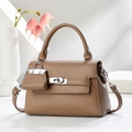 Sac à main en cuir marron avec poignée et mini breloque assortie sur fond blanc épuré - Khaki