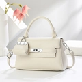 Détail du sac à main en cuir crème avec fermoir rotatif argenté et mini pendentif - Blanc Cassé
