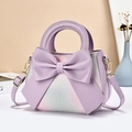 Detailed view of lavender handbag featuring a large bow and gradient floral embossing - Purple
