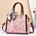 Pink floral jacquard handbag with silk scarf handle and adjustable strap in elegant setting - Pink