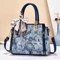 Blue embroidered handbag with silk scarf and gold hardware, front view with strap - Blue