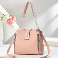 Detailed view of pink pebble leather handbag with silver square buckle and metal chain handle - Pink