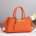 Détail d'un sac à main orange en cuir grainé avec poignées et finitions métalliques dorées - Orange