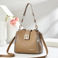 Brown leather crossbody bag with top handle and gold geometric logo on white pedestal - Khaki