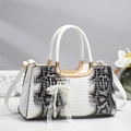 Dettaglio borsa bianca a trama serpentina con finiture dorate e fiocco di perle - Bianco