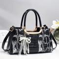 Elegante borsa in coccodrillo nero con manici dorati e ciondolo con fiocco in pizzo e perle - Nero