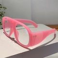 Vista macro de gafas rosas con filtro de luz azul en un soporte de exhibición minimalista - Marco Rosa