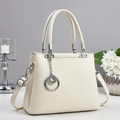 Elegant off-white lychee texture handbag with silver ring charm on a minimalist desk - Off-white