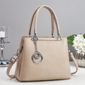 Sac à main élégant en cuir grainé beige avec breloque anneau argentée sur table blanche - Khaki