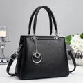 Detail of black pebbled leather tote with silver hardware and double ring pendant charm - Black