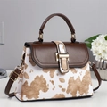 Fashionable cow print crossbody bag with brown leather handle and gold hardware detail - Apricot