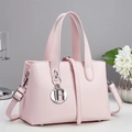 Detailansicht der hellrosa Handtasche mit silbernem DR-Metallanhänger und Lederstruktur - Rosa (A96254)