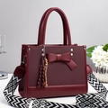 Burgundy bow handbag with geometric woven strap and colorful tassel accessory - Red