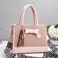 Pink bow handbag with woven texture and a stylish geometric crossbody strap - Pink