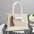 Détail du sac à main beige élégant avec nœud en tissu texturé et bandoulière tissée stylée - Blanc Cassé