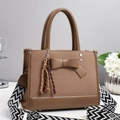 Gros plan du sac cabas marron avec texture tissée, nœud et breloque arc-en-ciel - Marron