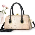 Detail of crocodile embossed pink tote featuring black patent handles and crystal clasp - Light Khaki