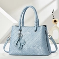 Dettaglio borsa blu in ecopelle con trama intrecciata e manici a spirale decorati - Blu
