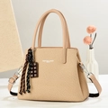 Detail of beige woven texture crossbody bag with leather handles and chocolate charm - Khaki