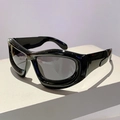 Detailed close-up of glossy black wide-frame Y2K bubble sunglasses on a white pedestal - Bright Black