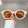 Detalle de gafas de sol retro con montura redonda crema y remaches metálicos decorativos - Montura Beige Lente Té