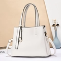 Borsa tote bianca in ecopelle con dettagli dorati e tracolla in un ambiente chic - Bianco