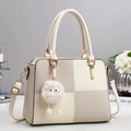 Chic cream patchwork handbag with plush charm, top handle and adjustable strap - White