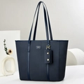 Close-up of a navy blue woven tote bag with two long shoulder straps and metallic logo plate - Blue