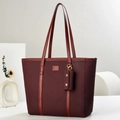 Detail of burgundy woven tote bag with smooth leather trim and metal logo plaque - Burgundy