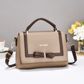 Detail of beige textured leather handbag with brown bow and golden metal hardware - Khaki