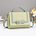 Detail of light green crossbody bag featuring pebble leather and a decorative bow - Green