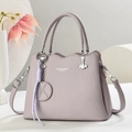 Detalle del bolso de cuero lavanda con borde ondulado y herrajes metálicos plateados - Gris Bruma