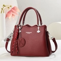 Detalle del bolso tote de cuero granate con herrajes plateados y colgante trenzado - Rojo