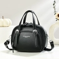 Gros plan du cuir noir grainé et des finitions métalliques argentées du sac - Noir
