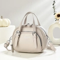 Détail du sac en cuir grainé blanc crème avec fermetures éclair et boucles argentées - Gris clair