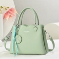 Elegante bolso de mano de cuero verde claro con bandolera y colgante decorativo - Verde