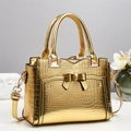 Golden embossed crocodile pattern handbag with bow detail and adjustable strap - Gold