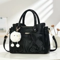 Elegante borsa in pelle marmorizzata nera con logo dorato e ciondolo di peluche - Nero