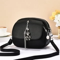 Minimalist black pebbled leather shoulder bag with silver bear pendant and fringe charm - Black
