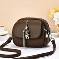 Detail view of brown lychee leather bag featuring three zipper layers and bear charm - Coffee