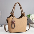 Vue détaillée du sac seau beige texturé avec pendentif étoile et poignées marron foncé - Khaki
