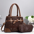 Detail of dark brown snake pattern tote bag with matching crescent pouch and bow accent - Coffee