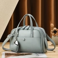 Détail du sac Boston bleu gris en cuir grainé avec charm en forme de coeur - Bleu Ciel