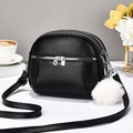 Borsa a tracolla nera in pelle martellata con cerniere a più strati e pompon bianco - Nero